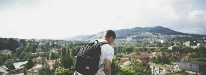 Image of a student with a backpack on campus