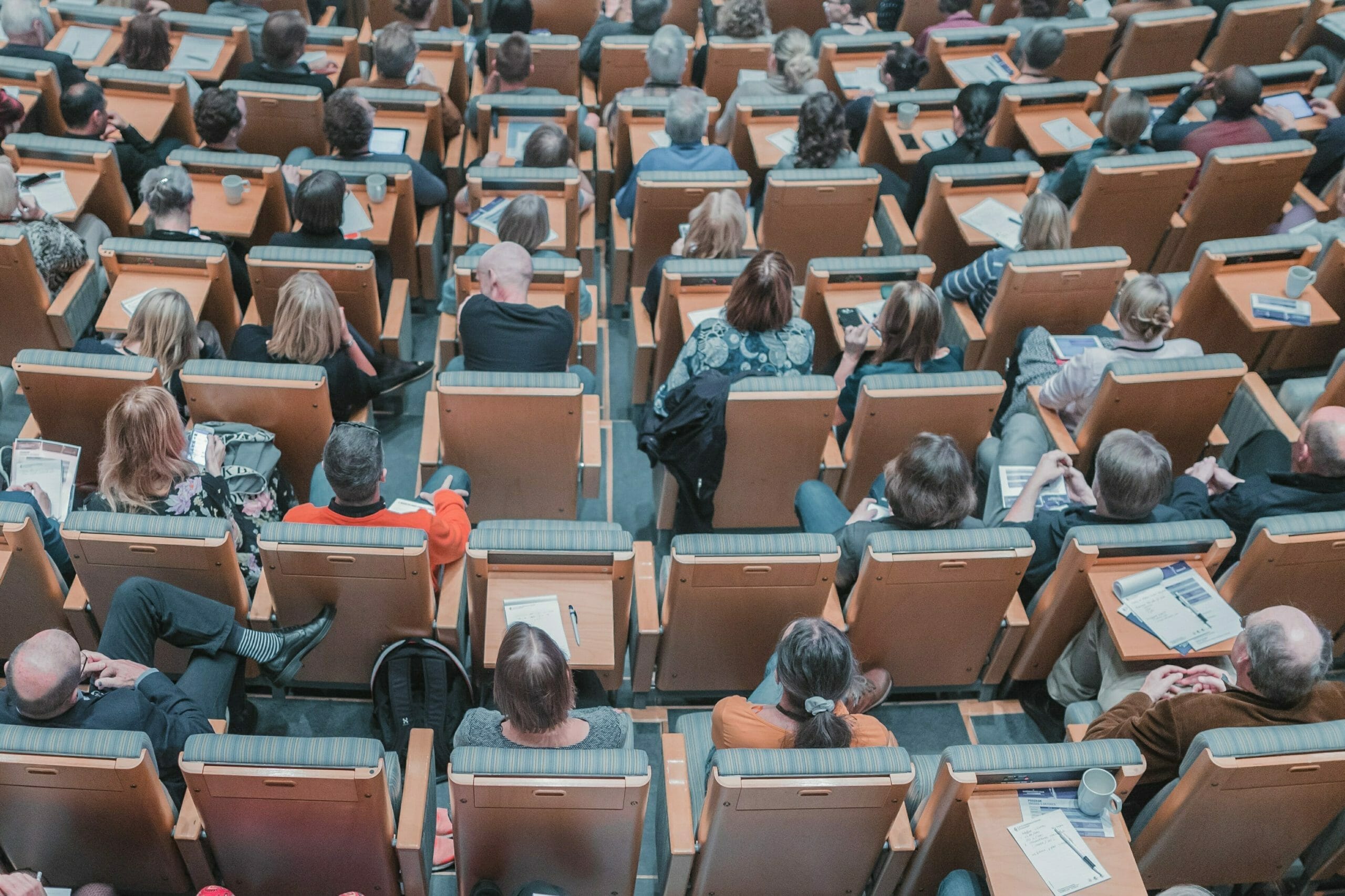 Image shows a lecture hall crowded with students