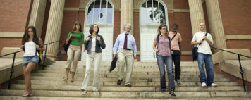 diverse students walking out of a campus building