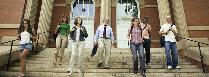 diverse students walking out of a campus building