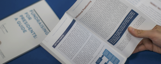 AI books person reading an Academic Impressions book "Fundraising for Presidents: A Guide"