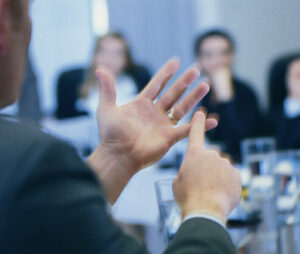 a man using hand gestures to explain tips to a team