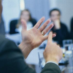 a man using hand gestures to explain tips to a team