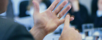 a man using hand gestures to explain tips to a team