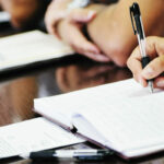 panelists taking notes during a meeting