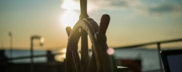 wheel of a ship in the sunset