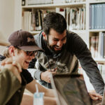 students laughing while using computers