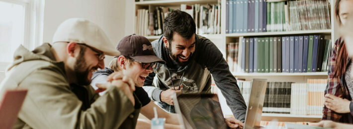 students laughing while using computers