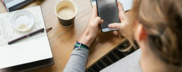 From Information Overload to Collaborative Learning - Higher Tech for Higher Ed: Image of student holding a smartphone