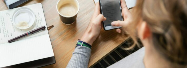 From Information Overload to Collaborative Learning - Higher Tech for Higher Ed: Image of student holding a smartphone