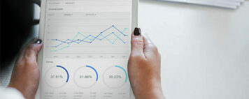 person looking at data charts on a tablet screen