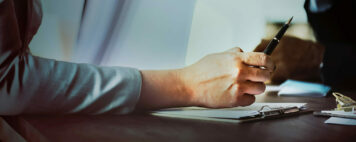 woman holding a pen over a clipboard