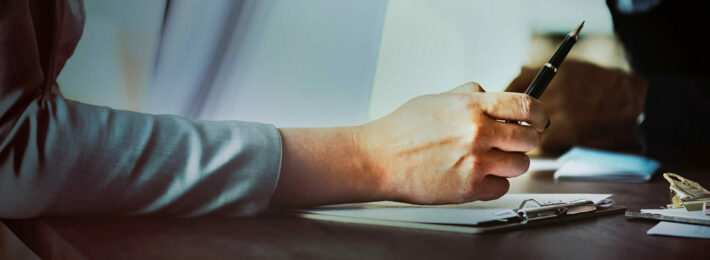 woman holding a pen over a clipboard