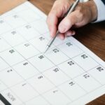 person about to write in a printed calendar