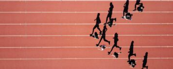 birds eye view of students running on a track in a V formation