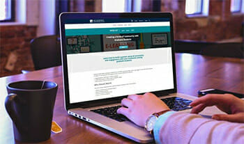 Title IX trainings are available with an AI membership; Photo shows a higher-ed professional logging into the membership on a laptop.