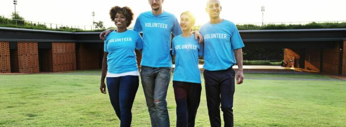 Alumni volunteer engagement: Image of four alumni volunteers in blue "volunteer" shirts