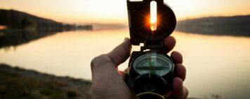 Higher Education Mergers - Image of a Compass at Sunset