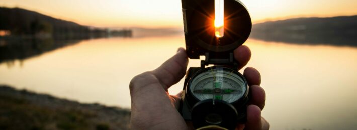 Higher Education Mergers - Image of a Compass at Sunset