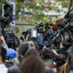 A crowd of people holding up professional camera gear.