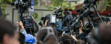 A crowd of people holding up professional camera gear.