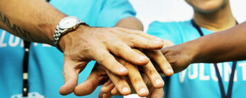 "Huddle up" hands together image for volunteers
