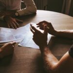 Image of several professionals having a brainstorming session at a wooden table