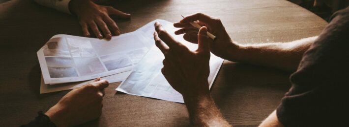 Image of several professionals having a brainstorming session at a wooden table