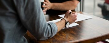 Workplace Bullying in Higher Education - Image of two colleagues arguing at a table