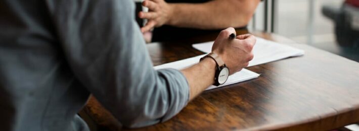 Workplace Bullying in Higher Education - Image of two colleagues arguing at a table