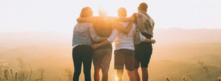 Developing Student Leaders - Image of Four Students Facing a Sunset Together