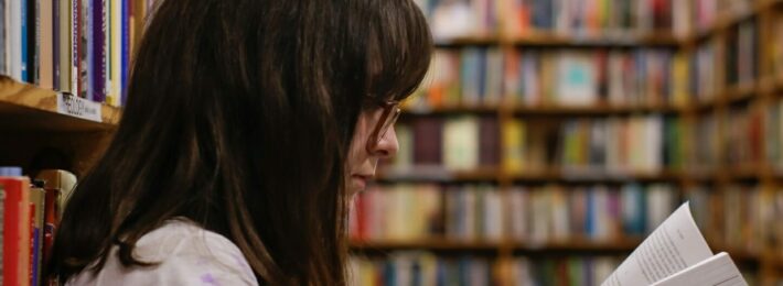 First Generation Students: Image of a woman reading at an academic library