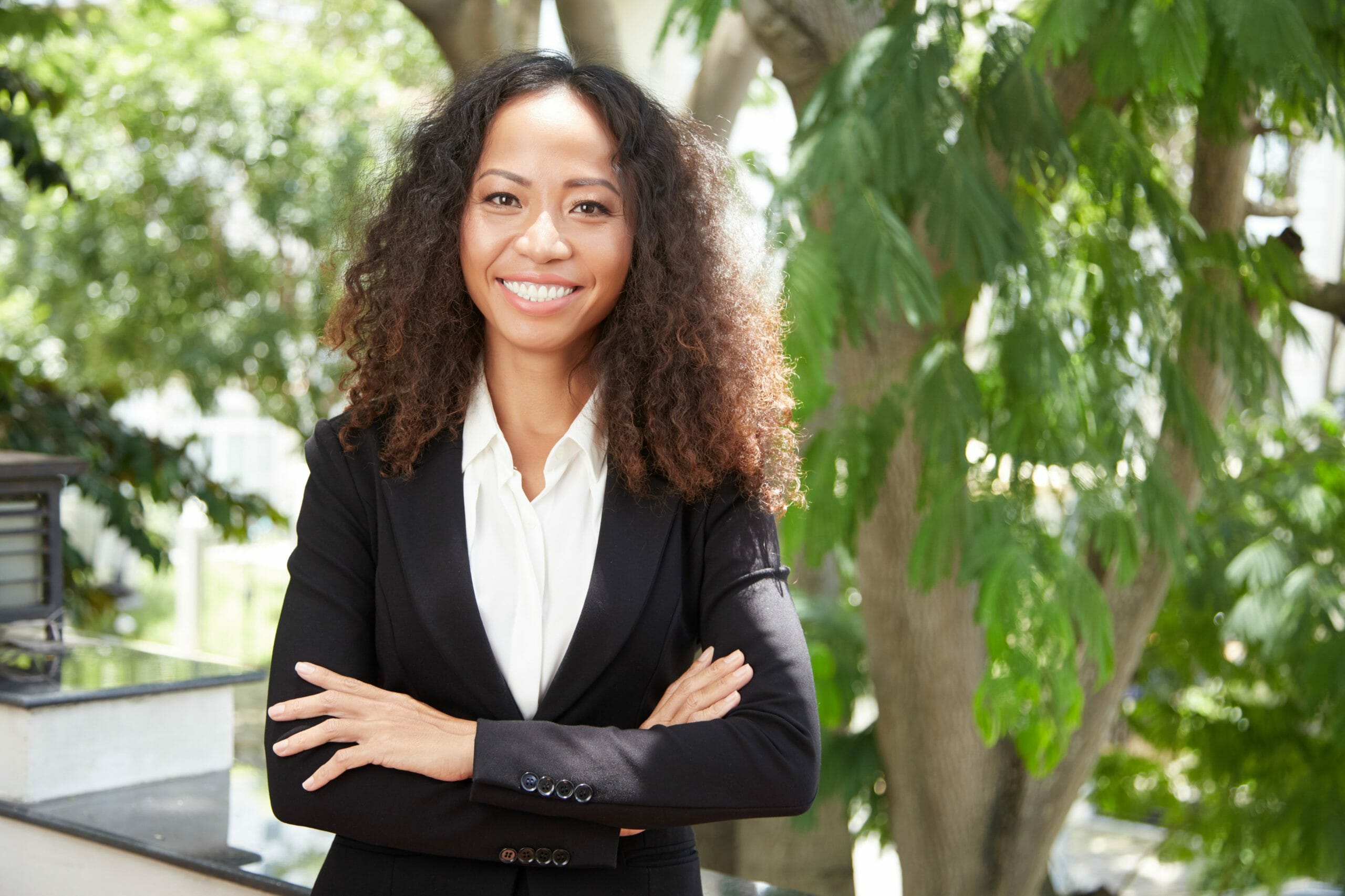 Cheerful businesswoman with hands crossed