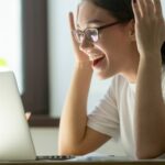 Young adult woman receiving good news via her laptop