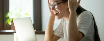 Young adult woman receiving good news via her laptop