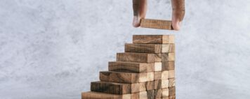 Stacking wooden blocks is at risk in creating business growth ideas.