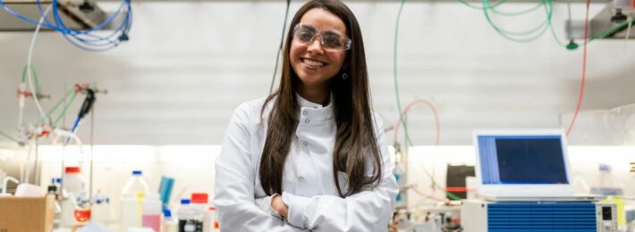 Image of a smiling researcher in a chemical engineering lab