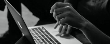 Black and white photo of a student at a laptop