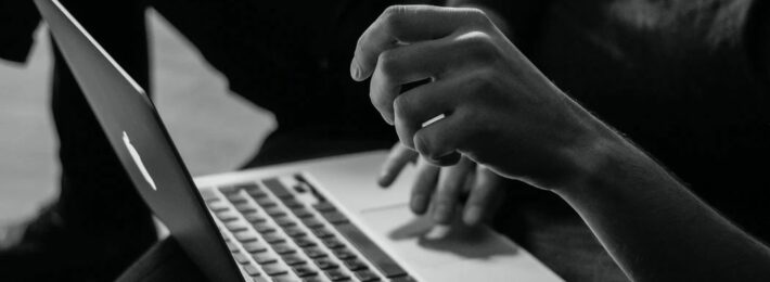 Black and white photo of a student at a laptop