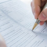 Close up of a female hand filling out an assessment form