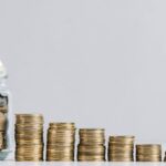 ascending stacks of coins with a person adding to a jar of coins to symbolize their donation