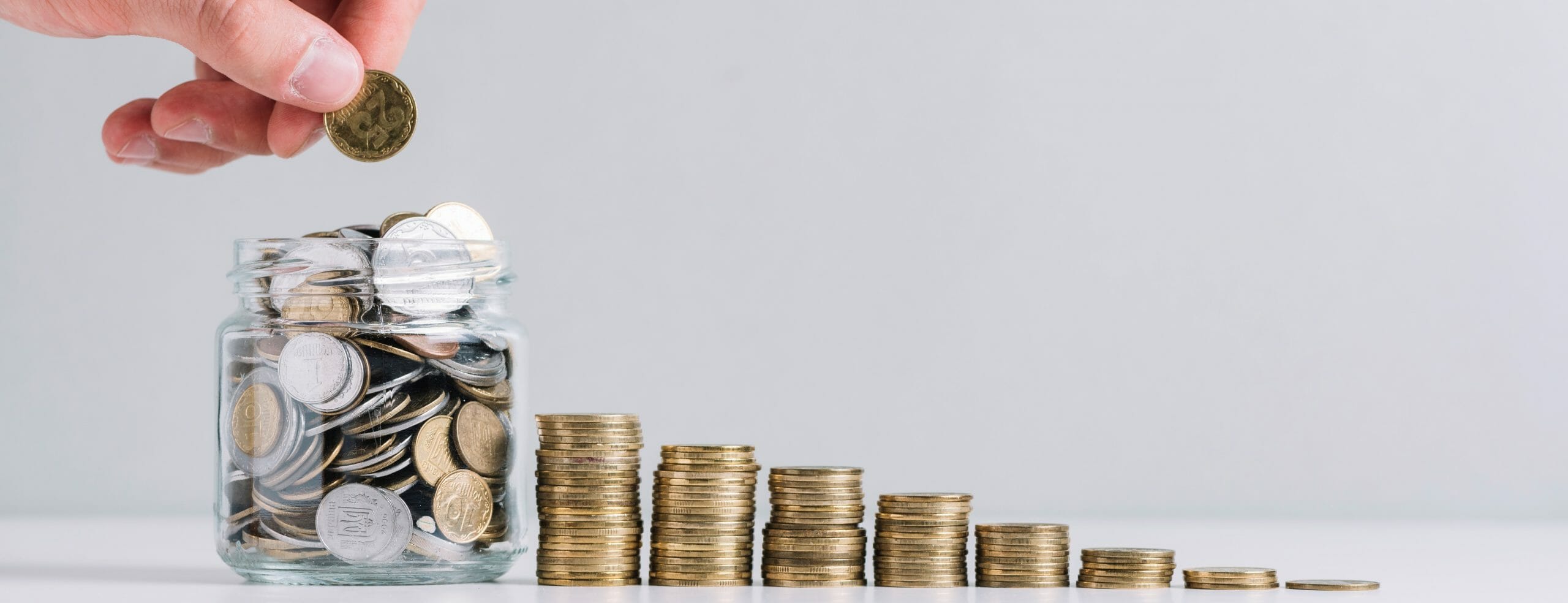 ascending stacks of coins with a person adding to a jar of coins to symbolize their donation