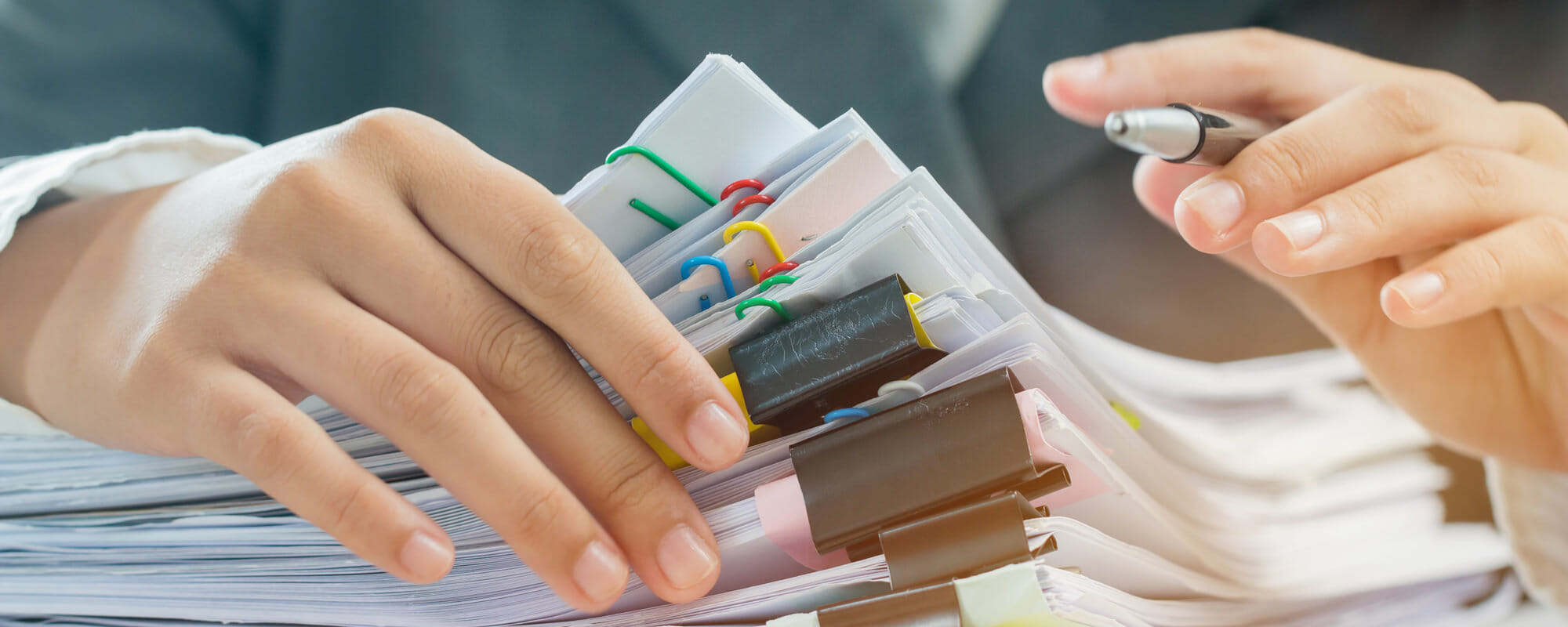 person looking through a stack of papers