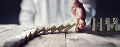 Hand stopping the domino effect