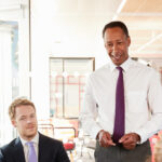 Black male manager addressing employees in a meeting