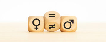 Wooden block turning a unequal sign to a equal sign between symbols of men and women