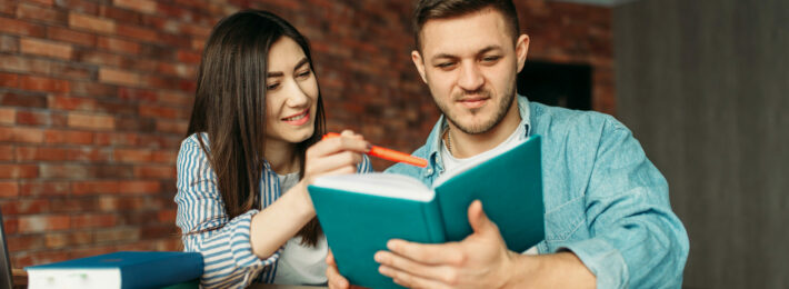 University students reading textbook together