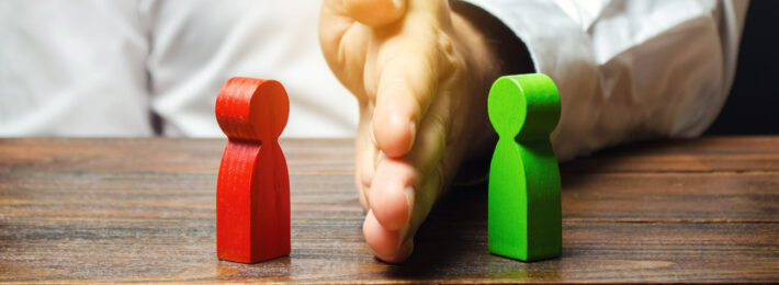 Hand dividing two wooden block figures