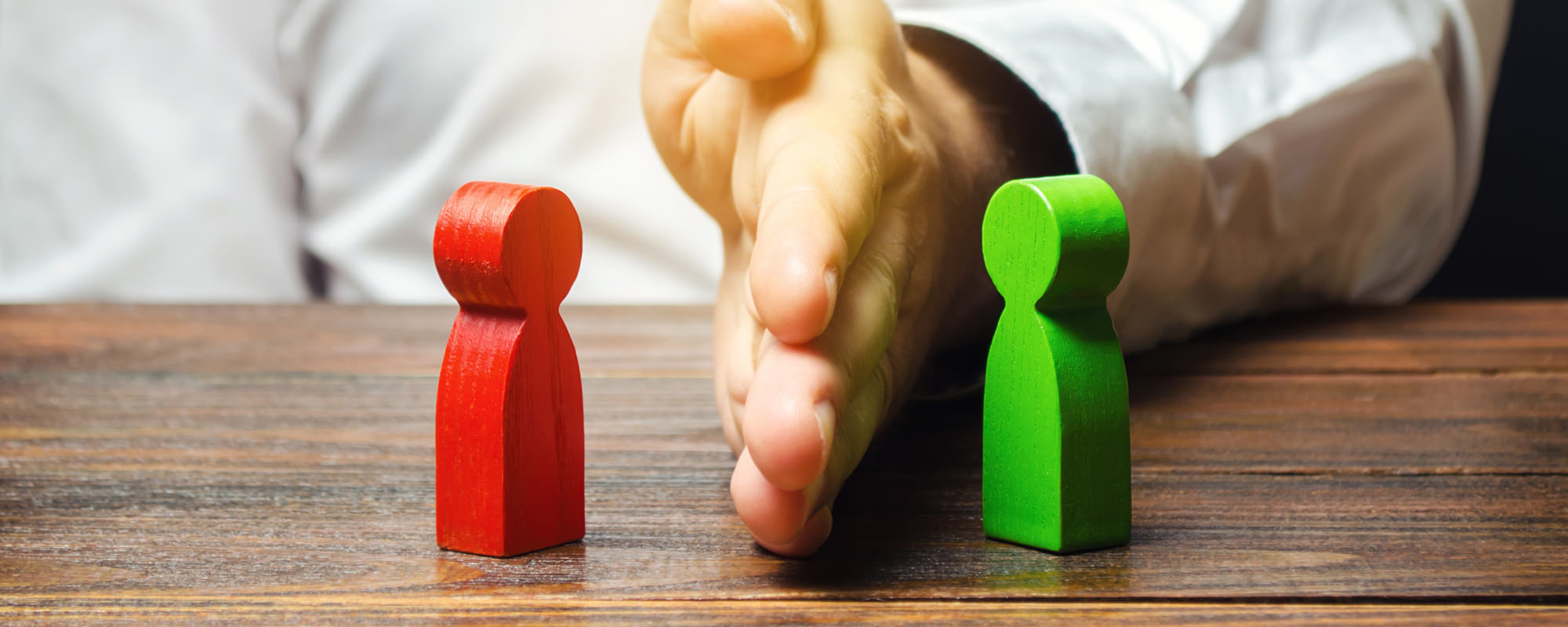 Hand dividing two wooden block figures