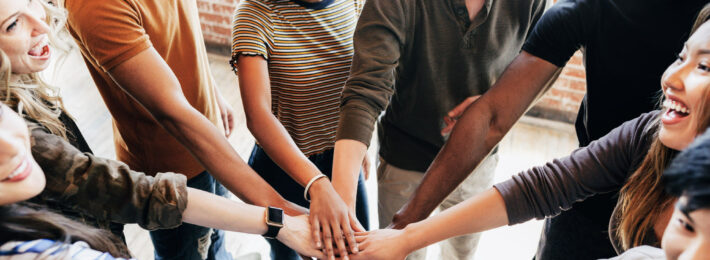 Diverse people stacking hands